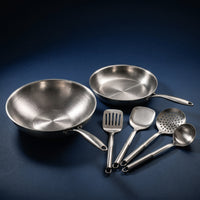 Handgehamerde titanium wok en koekenpan van 10 inch met vier stuks roestvrijstalen keukengerei op een donkerblauwe achtergrond