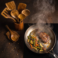 Houten keukengereiset naast een pan met steak en gebakken groente, van bovenaf gezien