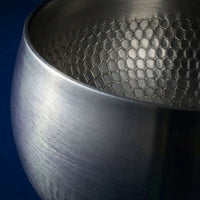 Close-up van de geborstelde buitenkant en de gehamerde binnenkant van de diepe titanium kookpan