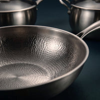 Close-up van de gehamerde binnenkant van de wokpan uit de titanium basis-keukenset
