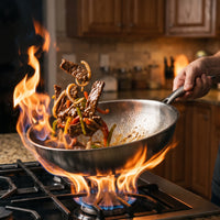 Roerbakgerecht met rundvlees en paprika wordt opgegooid in de titanium wok boven hoge vlammen